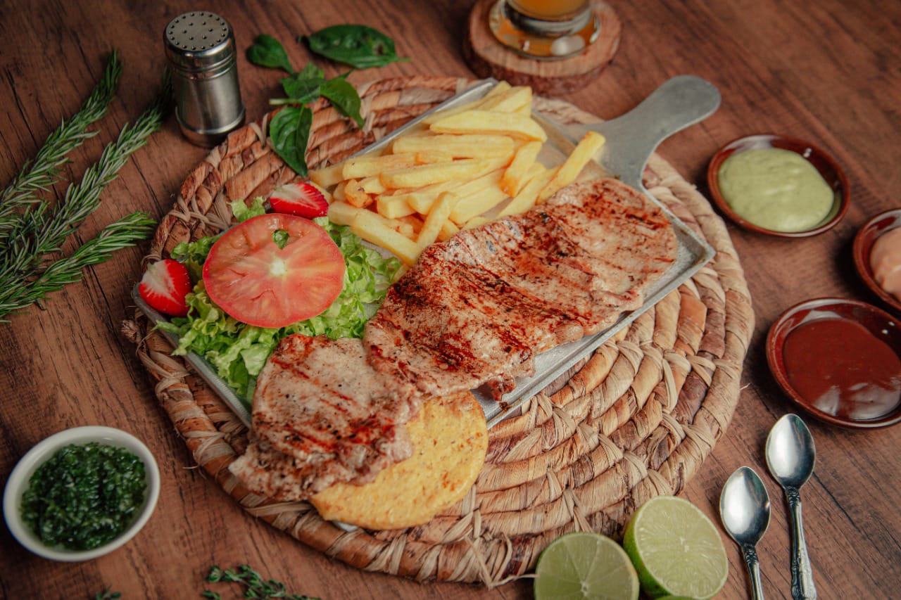Chuletas de cerdo con arepa y papas